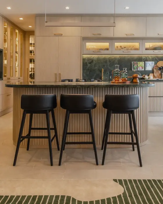 Congesa Seasons: banquetas pretas no balcão da cozinha, com adega iluminada ao fundo